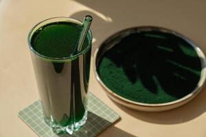 Organic blue-green algae spirulina detox drink in glass powder food. Health protein cocktail smoothie of chlorella. Vitamins and minerals to diet. Prebiotic and antioxidant rich Dietary supplement Seaweed superfood concept photo