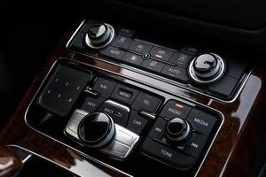 Interior of modern luxury car. Details of automatic transmission gear shift, multimedia control system, car control panel, Air Vent Red emergency button and dashboard inside. Prestige sport automobile. Selective focus photo