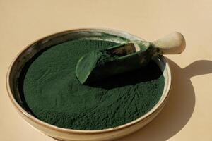 natural orgánico verde espirulina algas polvo en cuenco y de madera cuchara en neutral antecedentes. Chlorella algas marinas vegano superalimento suplemento fuente y desintoxicación Copiar espacio sano nutricional antioxidante concepto foto