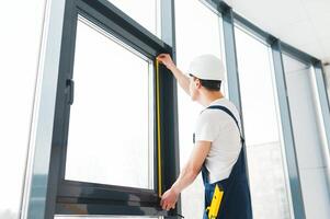 trabajador de la construcción instalando ventana en casa foto