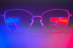 Stylish glasses shot using pink and blue abstract colored lighting with copy space. photo