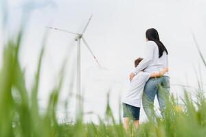 Alternative energy, wind farm and happy time with your family. Happy mother on the road with his son on vacation and escape to nature. photo