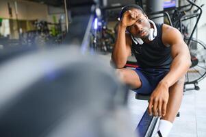 Tired, breathing and fitness gym man taking a break from workout photo