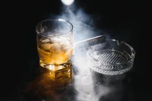 Whiskey drink with smoking cigar photo