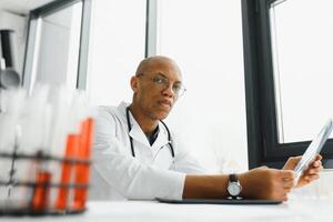 African American man male hospital doctor in white coat with stethoscope. photo