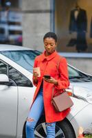 utilizando teléfono inteligente mientras espera. mujer en el eléctrico carros cargar estación a tiempo de día. marca nuevo vehículo. foto