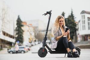 Beautiful young woman sitting on her electro scooter . photo