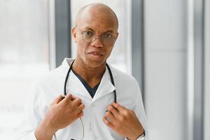 africano americano hombre masculino hospital médico en blanco Saco con estetoscopio. foto