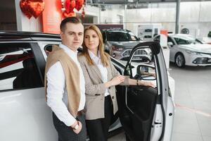 Young couple byuing a car in a car showroom. photo
