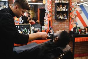 joven afroamericano hombre visitando barbería foto