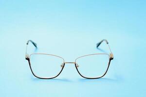 pair of red plastic-rimmed eyeglasses on a blue background photo