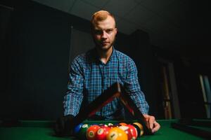 Thoughtful man plays billiards. Billiard room on the background. photo