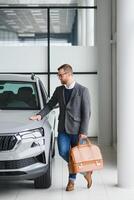 Man minded customer male buyer client in suit choose auto to go look aside want buy new automobile in car showroom vehicle salon dealership store motor show indoor Sales concept photo