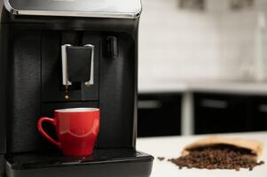 Modern coffee machine on table in kitchen photo