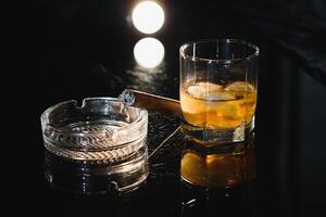 Whiskey drink with smoking cigar photo