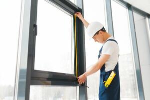 Professional handyman installing window at home. photo