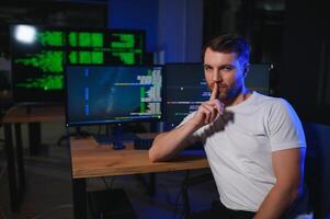 Young Handsome Man in Working on Desktop Computer. Digital Entrepreneur Typing Code photo