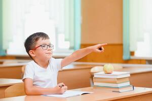 School boy in classroom at lesson photo