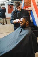 joven afroamericano hombre visitando barbería foto