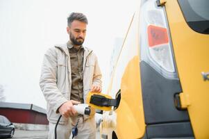 Man holding power connector for electric car photo