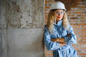 Young woman worker with a white helmet on the construction site. photo