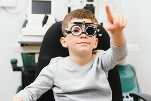 alegre niño chico en lentes cheques ojo visión pediátrico oftalmólogo foto