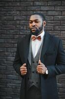 Fashion portrait of a handsome young African American business man walking outdoors in a casual pose. photo