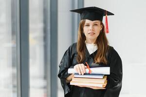 graduación estudiante en pie con diploma foto