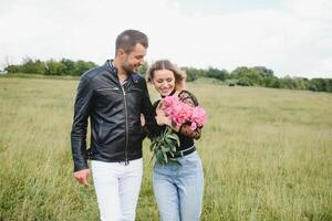 joven Pareja camina en el parque durante el primavera y abrazos. disfrutando hora juntos. el concepto de juventud, amor y estilo de vida foto