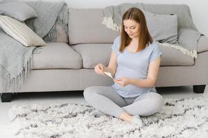 Pregnant woman looking at her baby sonography. Happy expectant lady enjoying first photo of her unborn child, anticipating her future life, copy space