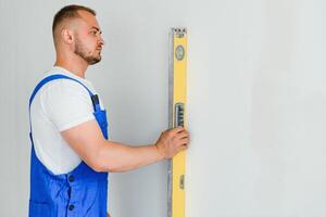 Repairman check the evenness of the wall using a spirit level. photo