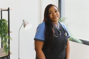 joven hermosa africano americano niña médico en un blanco Saco con un estetoscopio. foto