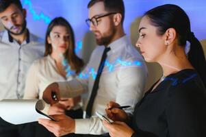 Group of business people working. Technical price graph and indicator, red and blue candlestick chart and stock trading computer screen background. Traders analyzing data photo