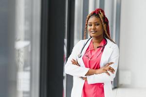 Portrait of female African American doctor standing in her office at clinic. photo