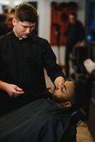 joven afroamericano hombre visitando barbería foto