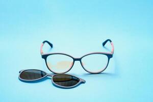 pair of red plastic-rimmed eyeglasses on a blue background photo