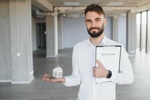 masculino real inmuebles agente con llave en habitación. bandera para diseño foto