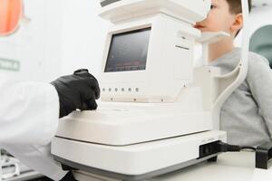 Vision correction in a boy. Close-up face of patient boy. Super modern equipment in a modern clinic for eye examination. photo