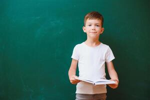 Back to school concept. School child in class. Happy kid against green blackboard. Smart child in classroom. Idea and education concept photo