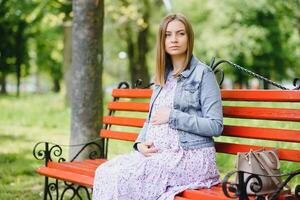 embarazada mujer descansando en el parque foto