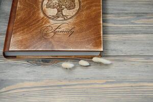 Luxury wooden photo book on natural background. Family memories photobook. Save your summer vacation memories.