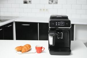 blurred background of kitchen and coffee machine with red cup and space for you photo