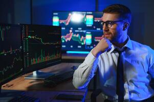 businessman comparing stock market data late in the evening photo