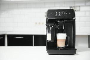hogar profesional café máquina con capuchino taza. café máquina latté macchiato capuchino Leche espuma preparar concepto foto