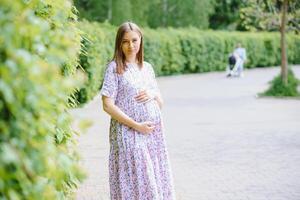 bella mujer embarazada relajándose en el parque foto