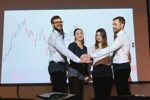 Group of business people working at modern office.Technical price graph, red and blue candlestick chart and stock trading computer screen background. Double exposure. Traders analyzing data photo