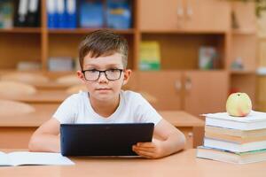 school boy using tablet compute in classroom photo