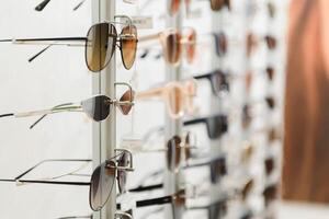 rack with glasses and sunglasses close up. photo