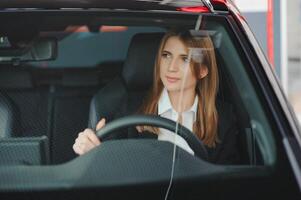 foto de contento joven mujer sentado dentro su nuevo coche. concepto para coche alquiler.