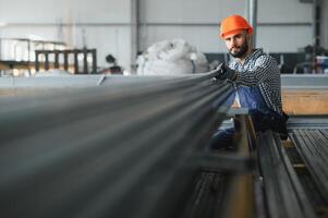 retrato de profesional pesado industria ingeniero trabajador vistiendo la seguridad uniforme, difícil sombrero sonriente. en el antecedentes desenfocado grande industrial fábrica. foto